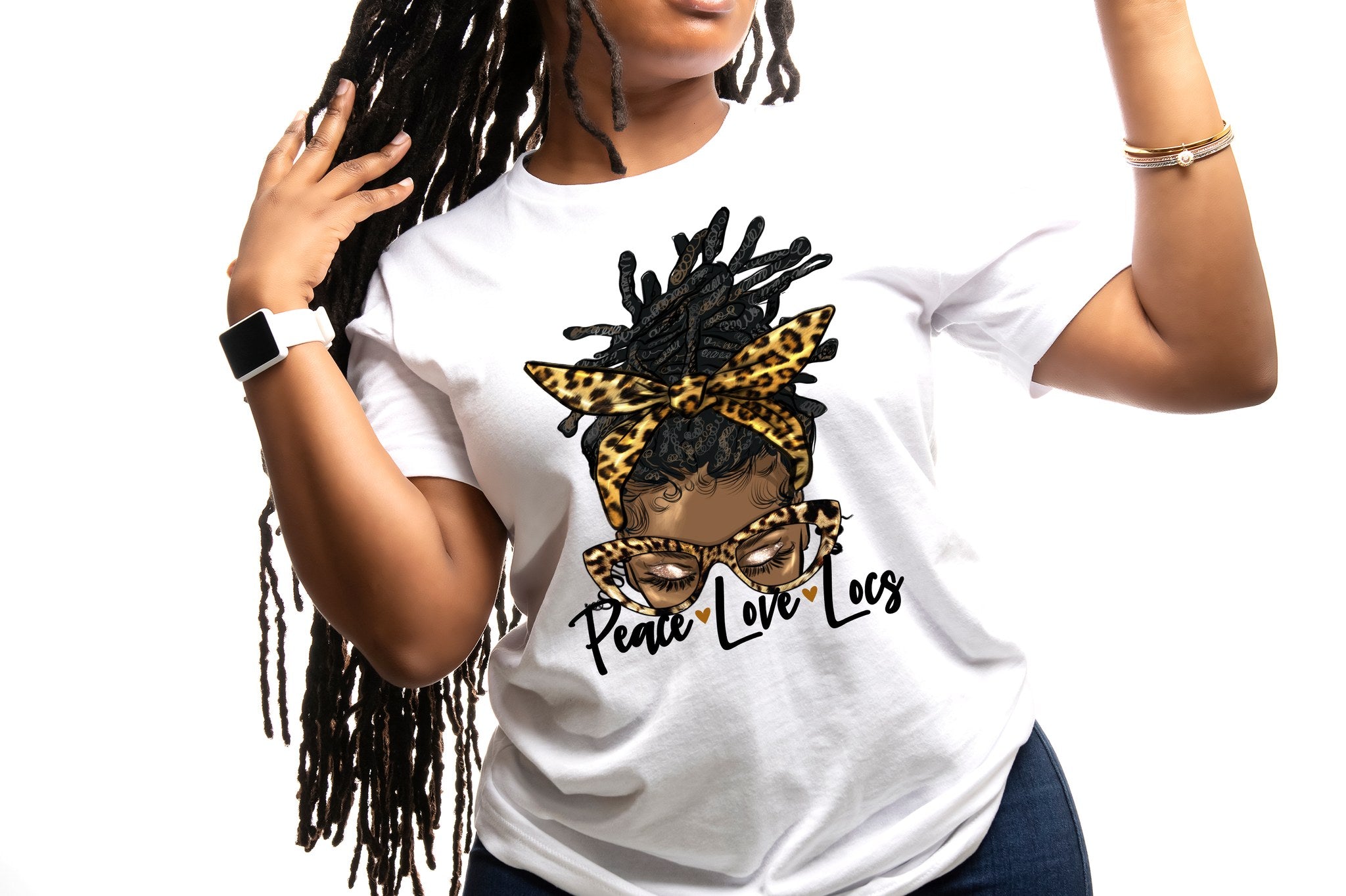 Woman showcasing a cotton shirt featuring Black culture designs, emphasizing peace and love with locs hairstyle.